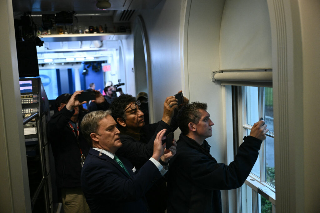 Reporters inside White House holding up smart phones