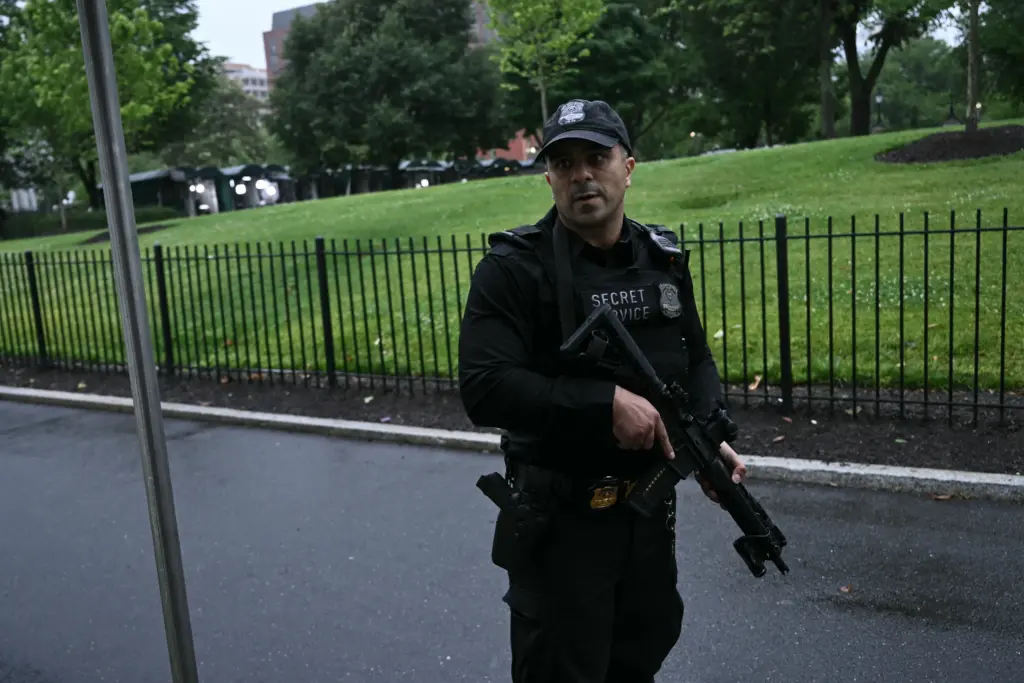heavily armed agent in black on White House driveway