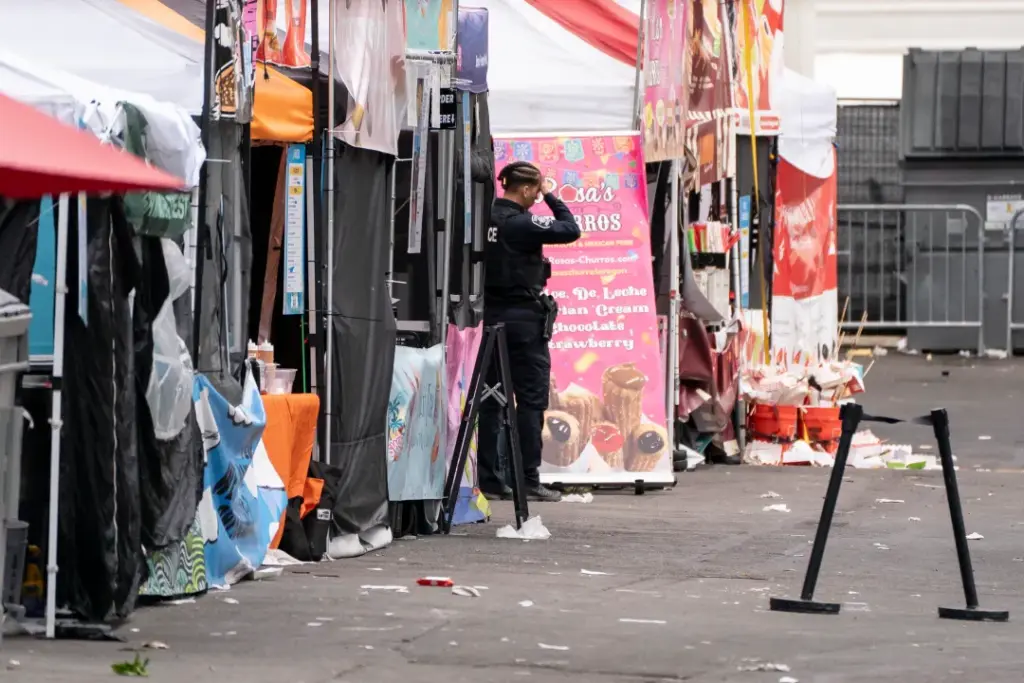 A police officer stands near abandoned vendor booths after a shooting