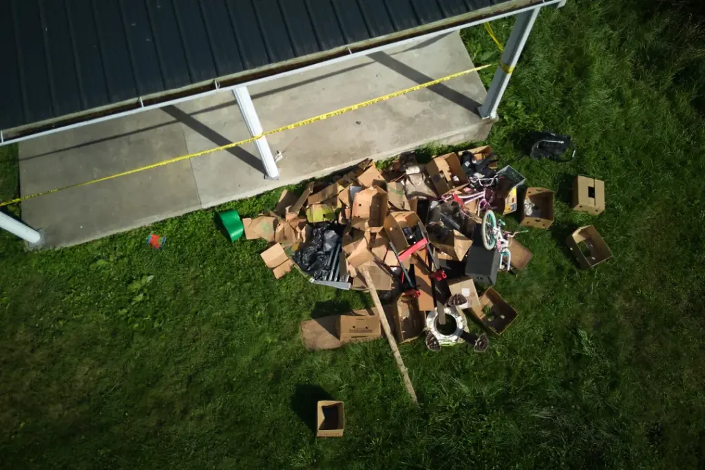 Debris is strewn on the front lawn of a home