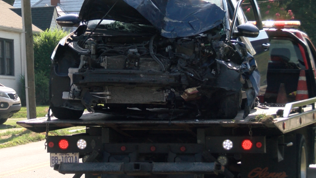 A car on the back of a tow truck with heavy front-end damage after a crash with a bus on North Driver Street and Holloway Street. (Ben Bokun)