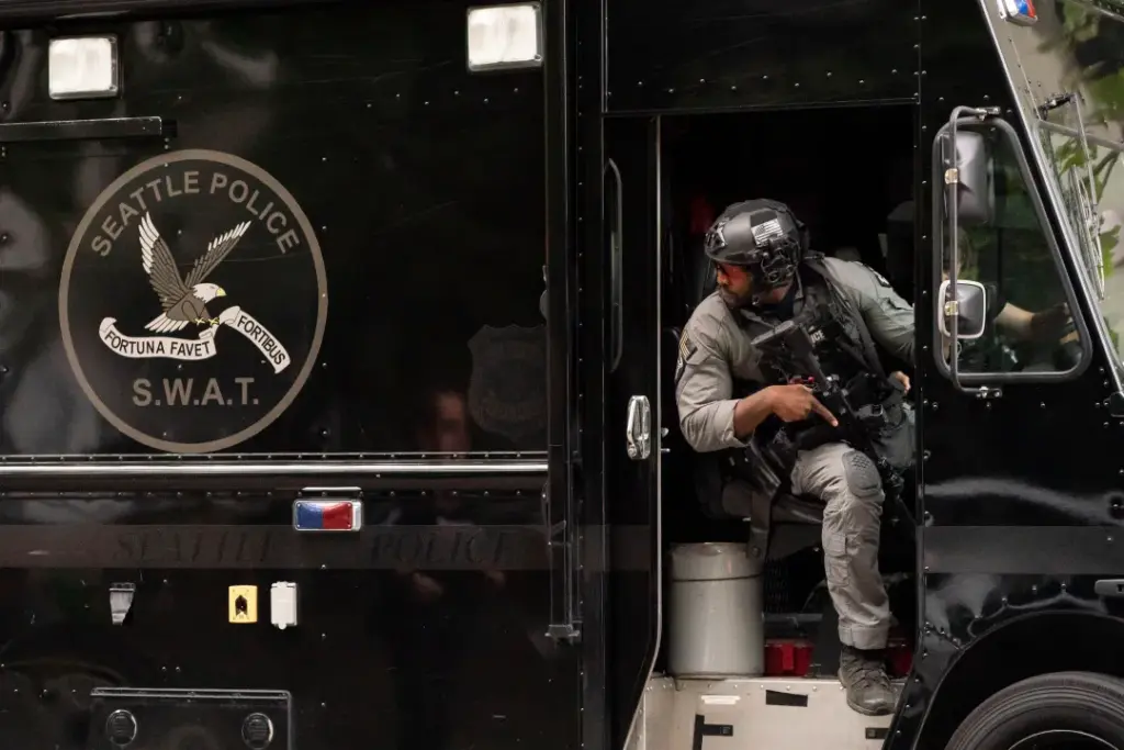A member of the Seattle Police S.W.A.T. team looks out of his vehicle