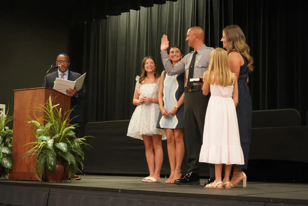 Sheriff Steve Maynor takes the oath of office as Rep. Robert Reives administers the oath during a ceremony July 30 at the Chatham County Agriculture & Conference Center in Pittsboro. Maynor's wife, Adrian, and daughters Riley, Remi and Rhetta stand beside him during the ceremony. (Chatham County Sheriff's Office)